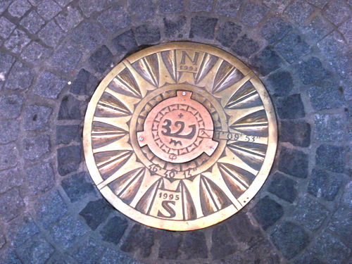 Brass plaque with Latitude, Longitude, Elevation, and a North-South Compass.